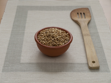 Close up view of organic Barley in a bowl with a wodden Spoonの写真素材