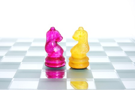 Two Knight chess pieces from opposite sides face off.の写真素材