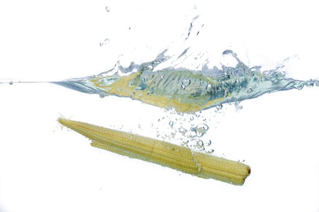 Fresh Babycorn drop to water in isolatedの写真素材