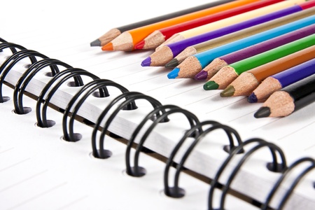 Color pencils in arrange in color wheel colors on note bookの写真素材