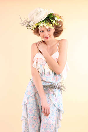 Beautiful woman with flowers on a yellow backgroundの写真素材