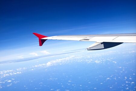 A view of wing of Airplane passenger clear sky and small cloudの写真素材