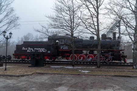Old steam locomotive at the station in the foggy winter day
