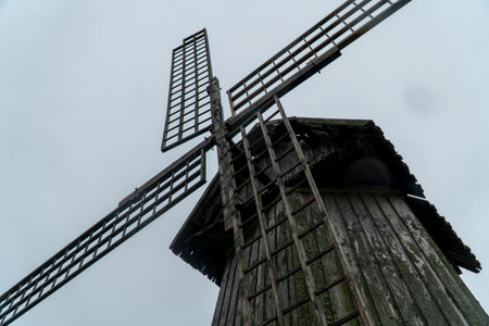 Old wooden windmill on cloudy sky background, closeup of photoの写真素材
