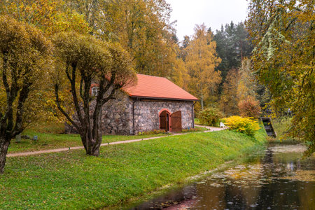 Autumn landscape with a church and a small river in the park Pushkinskie Gory, Pskov