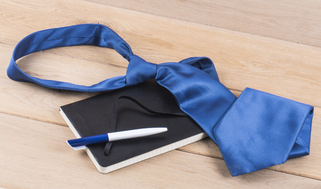 Image of notebook and tie wood background.の写真素材