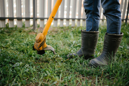 Gardening with a Hoe in Rubber Boots on Grass