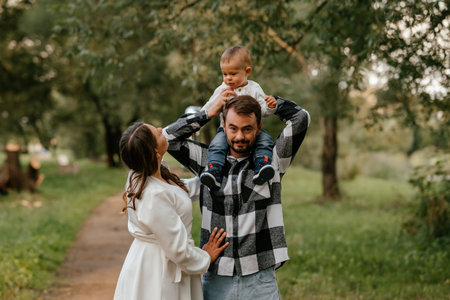 Family Walk in Park with Baby on Fathers Shouldersの写真素材
