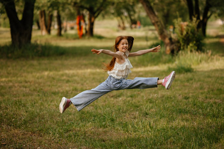 Joyful Girl Jumping in Park with Excitementの写真素材