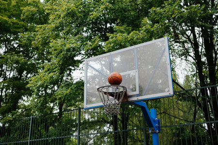 Basketball Going Through Hoop on Outdoor Courtの写真素材