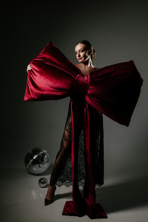 Elegant Woman in Dramatic Red Bow Dress with Confidenceの写真素材