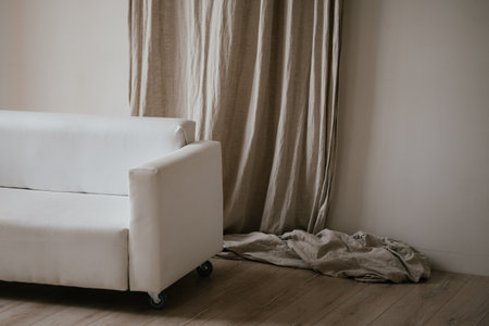 Minimalist White Couch Against Beige Drapesの写真素材