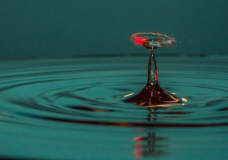 Water drop falling into water making a perfect droplet splashの写真素材