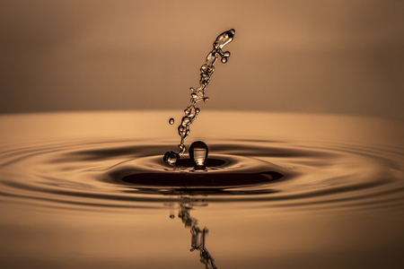 Water drop falling into water making a perfect droplet splashの写真素材