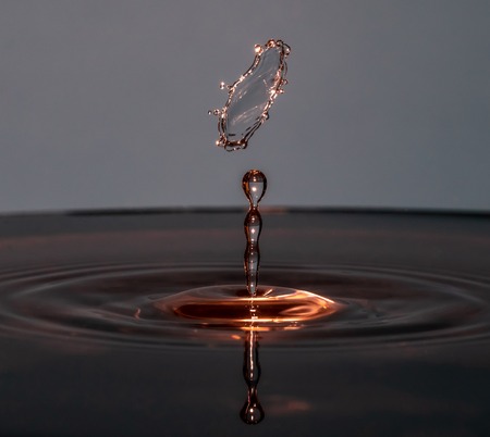 Water drop falling into water making a perfect droplet splashの写真素材