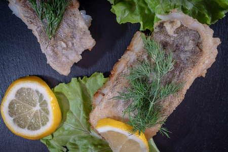 Dish of fish fillet with greens and lemonの写真素材