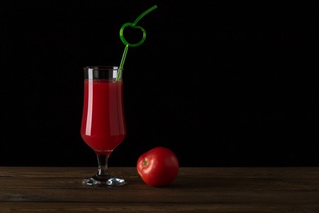 Tomato juice and tomato on a black backgroundの写真素材