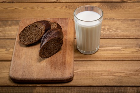 A Glass milk with bread slice on wood backgroundの写真素材