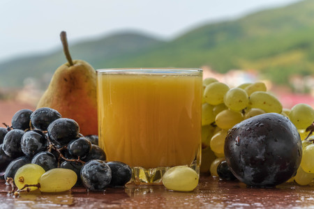Fresh fruits and juice against the sky and mountains. still lifeの写真素材