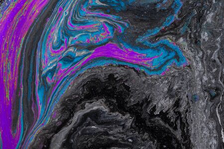 Abstract colored background from spilled paints closeup.