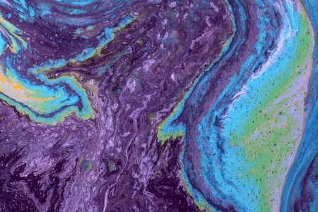 Abstract colored background from spilled paints closeup.