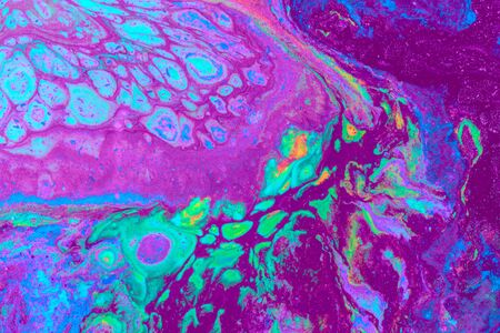 Abstract colored background from spilled paints closeup.