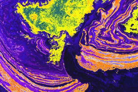 Abstract colored background from spilled paints closeup.