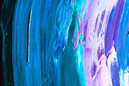 Abstract colored background from spilled paints closeup.