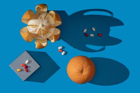 Oranges and vitamins on a blue background. View from above.