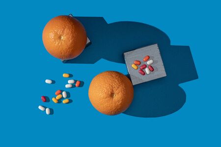 Oranges and vitamins on a blue background. View from above.の写真素材