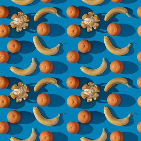 seamless pattern of photos of oranges and bananas on a blue background.の写真素材