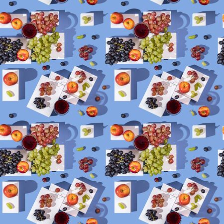 Grapes and apples on white parallelepipeds on a blue background top view, seamless pattern.の写真素材
