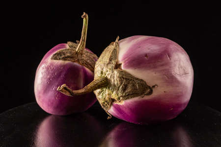 Ripe round eggplants on a black background close upの写真素材