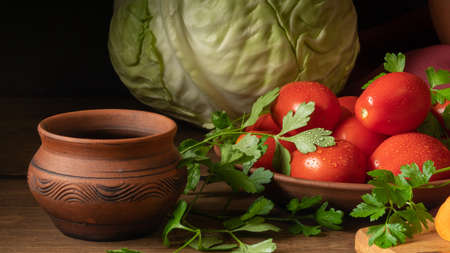 Still life with vegetables and a clay jug. Cabbage, tomatoes, carrots, parsley.の写真素材