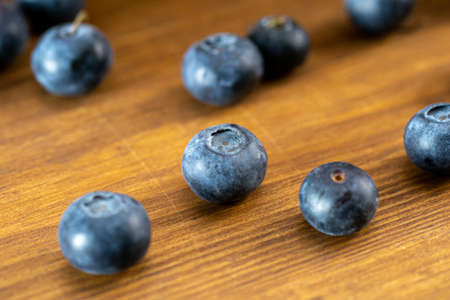 Several blueberries on a wooden table close-up.