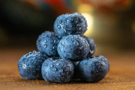 Several blueberries on a wooden table close-up.