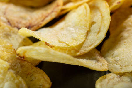Potato chips on a black background close-up.