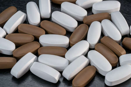 Vitamins in the form of pills on a black background.