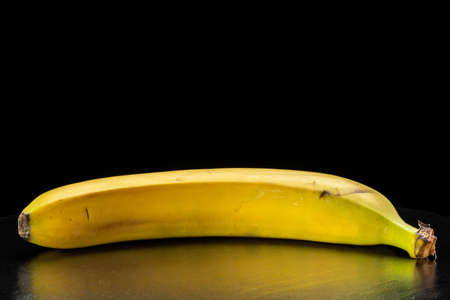 Ripe yellow banana on a black background.の写真素材