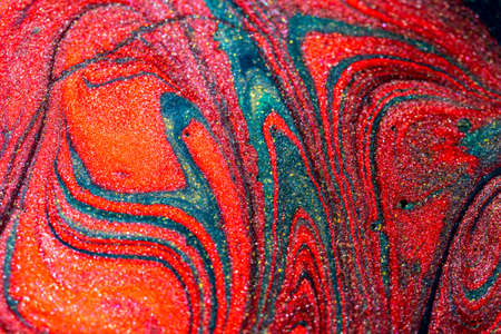 Abstract colorful background of mixed multicolored acrylic paints with sparkles
