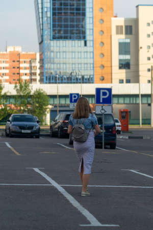 Woman walking towards a car in a parking lotの写真素材