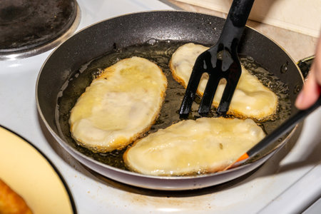 Woman frying pies in oil in a cast iron pan