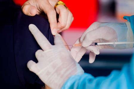 cropped image of the doctor making injection to a patient, covid conceptの写真素材