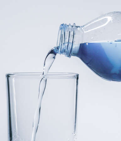 Pour clean drinking water from the bottle into the glass.の写真素材