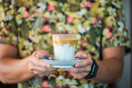 Barista serves milk coffee to customers.