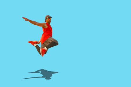 A picture of a male athlete jumping on a colored backgroundの写真素材