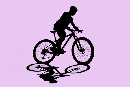 Silhouette of a man riding a bicycle for exercise on a colored background With clipping path.の写真素材