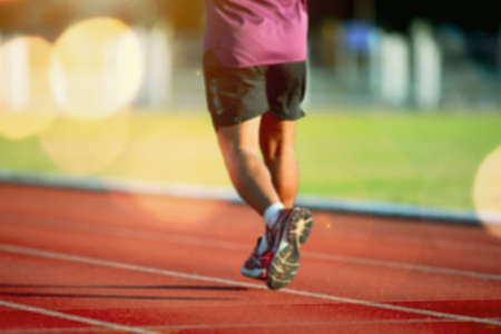 Blurred lens of a runner training hard on a hot track. male runner trainingの写真素材