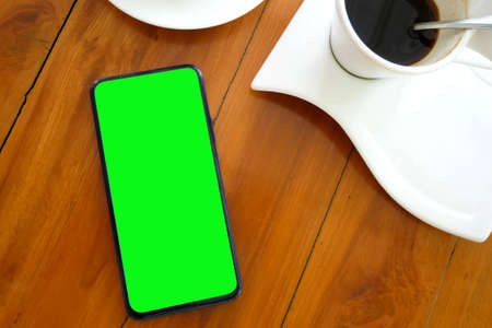 mobile phone Put it on the coffee table in the morning. Blank screen for working content with clipping pathの写真素材