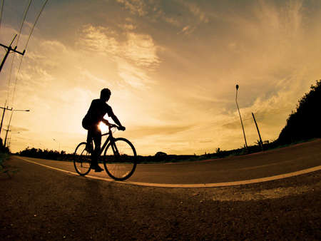 People exercise on bicycles in the evening. Sport in Nature background. The image of a cyclist in motion in the background in the eveningの写真素材